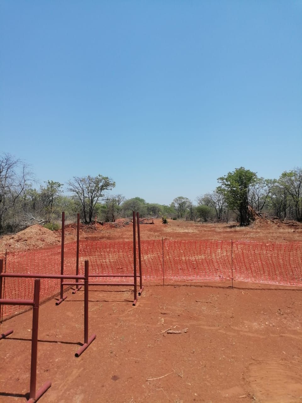 Barrier-mesh perimeter around the cleared drilling pad