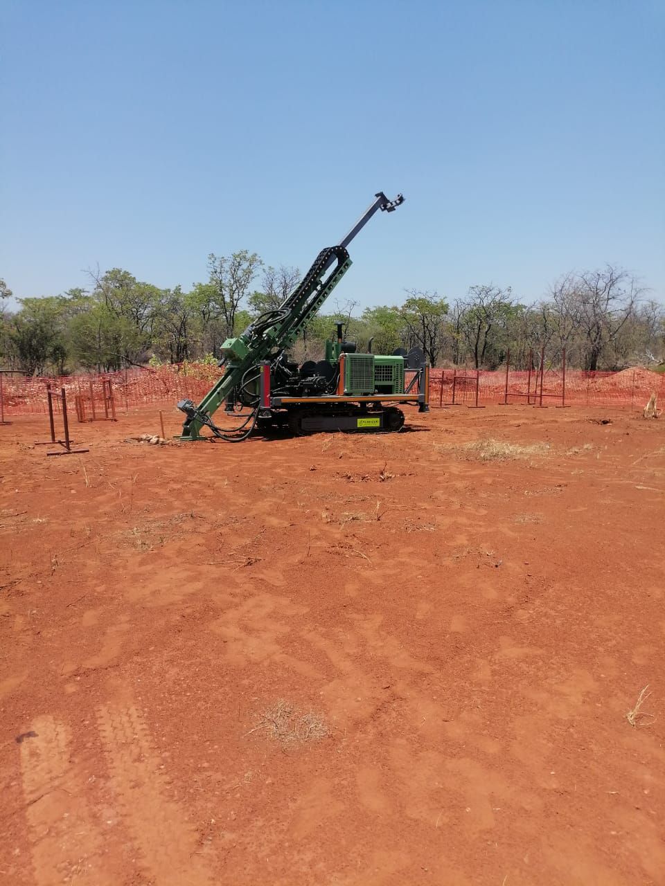 Exploration drill rig inside its barrier-mesh perimeter